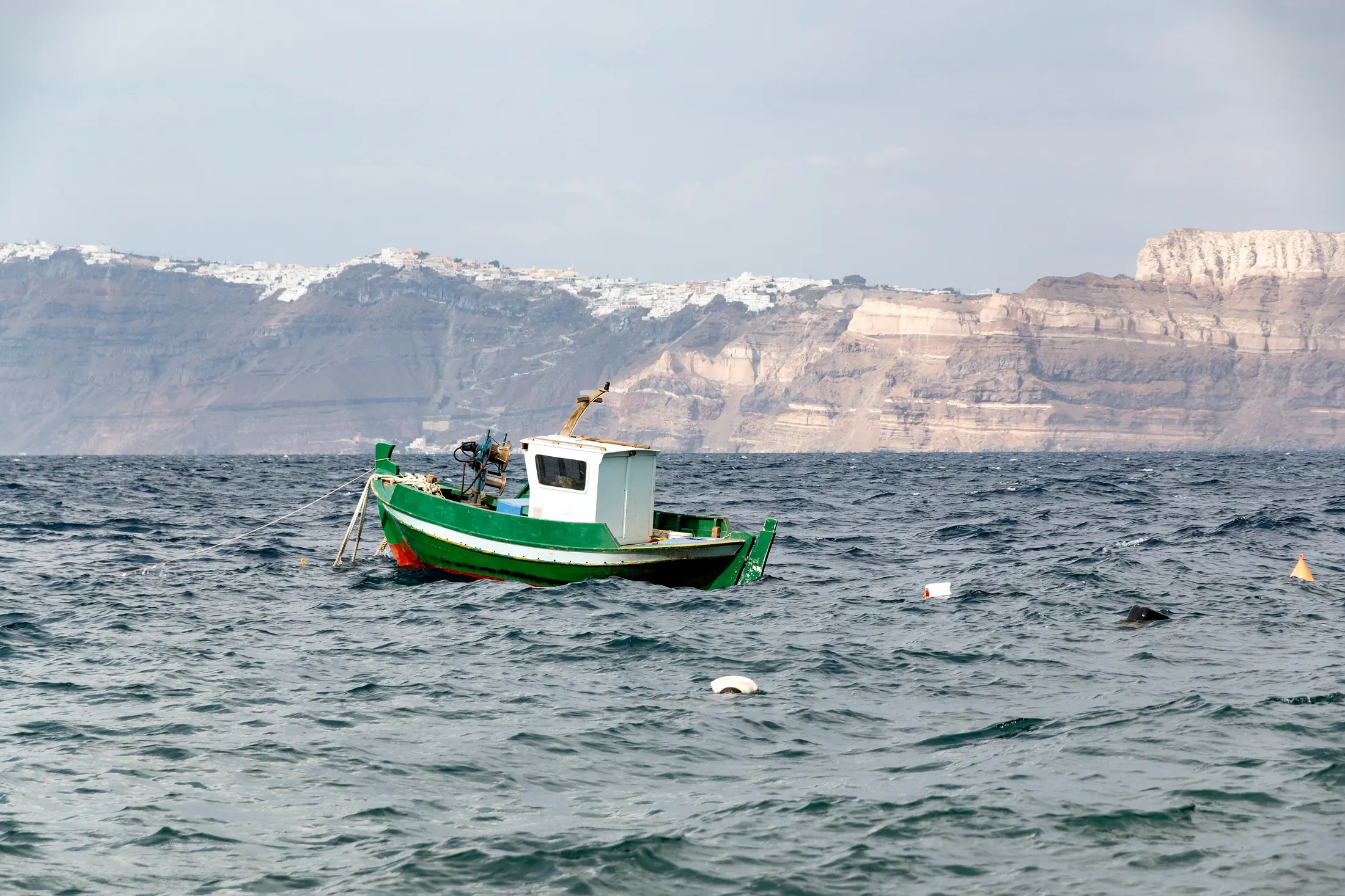 Boats in the caldera below the cliffs